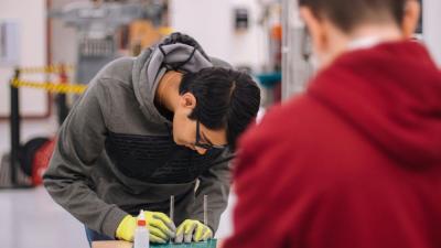 Junger Mann arbeitet in Werkstatt Junger Mann arbeitet in Werkstatt